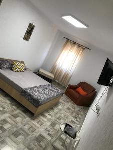 a bedroom with a bed and a chair at CASA DENIZ in 2 Mai