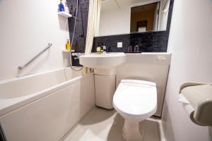 a bathroom with a white toilet and a sink at Rinn Gion Kenninji in Kyoto