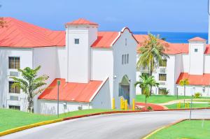 a large white building with red roofs and a road at Garden Villa Hotel in Tumon