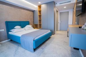 1 dormitorio con 1 cama azul y cocina en Hotel Prestige, en Mamaia