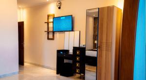 a living room with a television and a bedroom at Home Free Hotel in Kigali