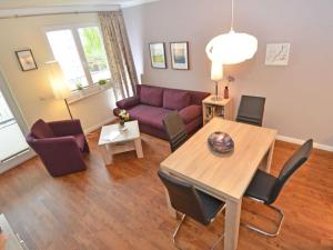 a living room with a table and a purple couch at Wohnpark Stadt Hamburg - Apt. 10 in Binz