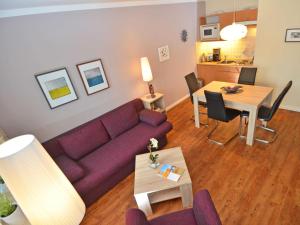 a living room with a purple couch and a table at Wohnpark Stadt Hamburg - Apt. 10 in Binz