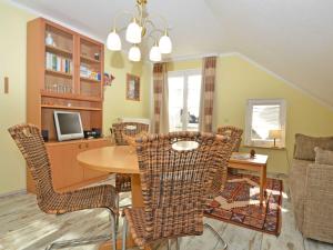 a dining room with a table and wicker chairs at Wohnpark Stadt Hamburg - Apt. 12 in Binz