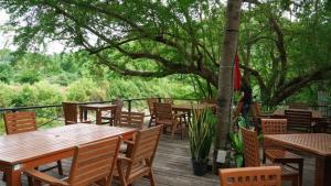 a group of tables and chairs on a wooden deck at GRANMONTE Wine Cottage in Phayayen