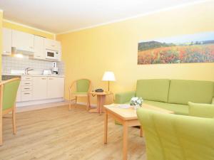 ein Wohnzimmer mit Couch und Tisch und eine Küche in der Unterkunft Wohnpark Stadt Hamburg - Apt. 15 in Binz
