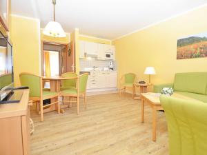 ein Wohnzimmer mit Tisch und Stühlen und eine Küche in der Unterkunft Wohnpark Stadt Hamburg - Apt. 15 in Binz