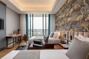 um quarto de hotel com uma cama king-size e uma secretária em Sayarsan Hotel Yangon em Yangon