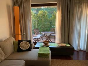 a living room with a couch and a table and a window at Apartament Bornholm in Jurata