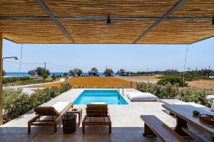 un patio con piscina, mesa y sillas en Akra Grammeno Beachfront Villas, en Palaiochóra