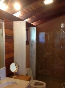 a bathroom with a shower and a toilet and a sink at Pipa Hills Casa Bromélia in Pipa