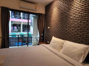 a bedroom with a brick wall and a bed at Dfeel House in Patong Beach