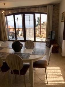 una sala da pranzo con tavolo e sedie e un balcone di Venetia's Stone House a Potamiá