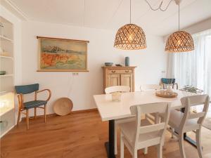 a dining room with a white table and chairs at Dorpsstraat 10 in Oost-Vlieland