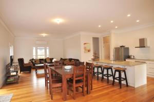 a kitchen and living room with a table and chairs at Paperbark Homestead Pet Friendly in Inverloch