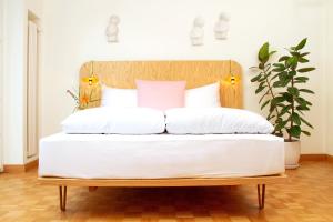 a bed with a wooden headboard and white pillows at Villa Maria in Luzern