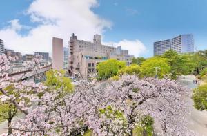 a view of a city withakura trees and buildings at Minamisenri Crystal Hotel in Suita