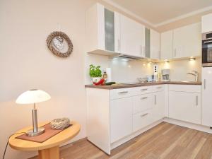 a kitchen with white cabinets and a table with a lamp at Wohnpark Stadt Hamburg - Apt. 22 in Binz