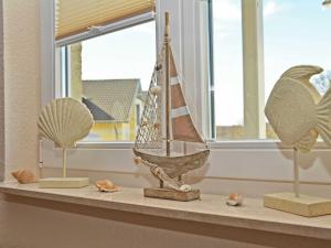 a shelf with a model boat on it next to a window at Wohnpark Stadt Hamburg - Apt. 22 in Binz