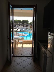 Una puerta que conduce a una cocina con vistas a la piscina en Michelangelo Holiday & Family Resort, en Lido di Spina