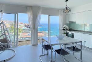 a kitchen with a table and chairs with a view of the ocean at PaulMarie Gigantes Fantastic View in Puerto de Santiago