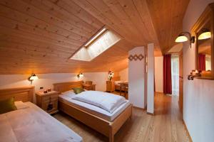 una camera con un grande letto e un soffitto in legno di Residence Merk a Selva di Val Gardena