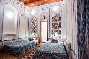 a hotel room with two beds and two lamps at Boutique Hotel Minzifa in Bukhara