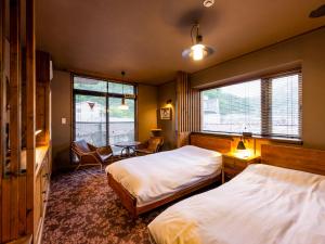a bedroom with two beds and a table and chairs at Hakone Villa Bizan in Hakone