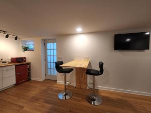 a kitchen with a wooden table and two black stools at Private Studio Close to Downtown Rhinebeck in Rhinebeck