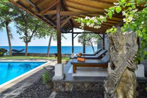 BuktiにあるVilla Kupu Kupuのリゾートの隣にあるパーゴラ付きのスイミングプール