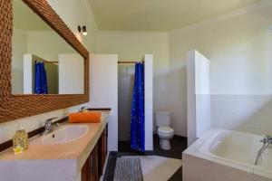 BuktiにあるVilla Kupu Kupuの浴槽、洗面台、鏡のあるバスルーム +30枚の写真