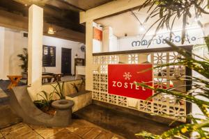 un restaurante con una señal roja en el lateral de un edificio en Zostel Alleppey, en Alleppey 34 fotos más