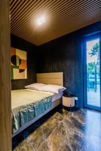 1 dormitorio con cama y ventana grande en Natura Park Radawa, en Radawa