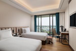 仰光Sayarsan Hotel Yangon的有两张床和一扇窗户的酒店房间