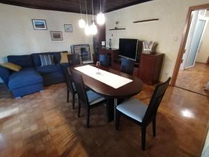 uma sala de estar com uma mesa e um sofá azul em APARTMA ŽELE em Postojna