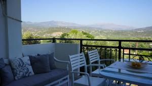 a balcony with a couch and a table and chairs at Urban Blue House in Agios Nikolaos