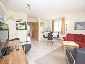 a living room with a red couch and a table at Wohnpark Stadt Hamburg - Apt. 37 in Binz