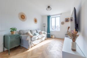 - un salon blanc avec un canapé et une fenêtre dans l'établissement Le Longeville, à Longeville-lès-Metz