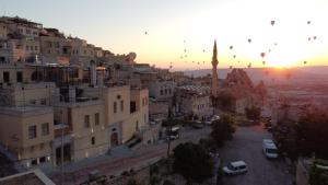 vista para uma cidade ao pôr-do-sol com uma mesquita em Kappadoks Cave Hotel em Üçhisar