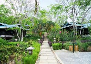 een tuin met een loopbrug voor sommige huizen bij The Orchard Resort & Spa Melaka I World Spa Awards Winner I Free Access to Outdoor Spa Pool in Melaka