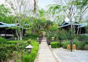 a garden with a walkway in front of some houses at The Orchard Resort & Spa Melaka I World Spa Awards Winner I Free Access to Outdoor Spa Pool in Malacca