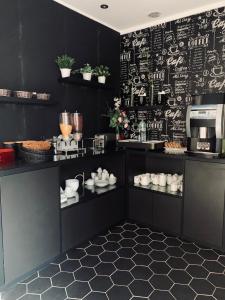 パリにあるホテル アジェノールの黒い壁のキッチン(黒いキャビネット付)