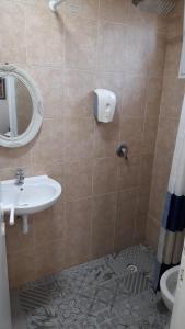 een badkamer met een wastafel, een spiegel en een toilet bij Hotel Loui Talpiot in Haifa