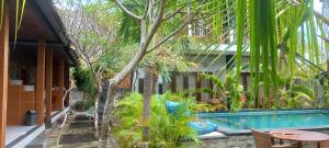 a resort with a swimming pool and palm trees at Swara Homestay 2 in Nusa Lembongan