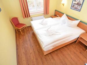 een groot wit bed in een kamer met een stoel bij Wohnpark Stadt Hamburg - Apt. 41 in Binz +6 foto's