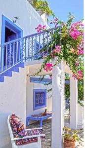 a patio with a blue staircase and pink flowers at Pleiades Alinda Bay Leros in Alinda