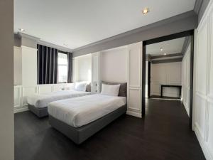 a large bedroom with two beds and a mirror at Penpark Place in Bangkok