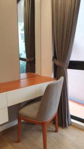 een bureau en een stoel voor een raam bij Era Cozy Apartment in Hanoi