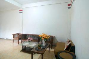 ein Wohnzimmer mit Sofas und einem Tisch mit Blumen darauf in der Unterkunft OYO 1847 Jasmine Kost Syariah in Jambi