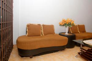 uma sala de estar com um sofá e um vaso de flores em OYO 1847 Jasmine Kost Syariah em Jambi